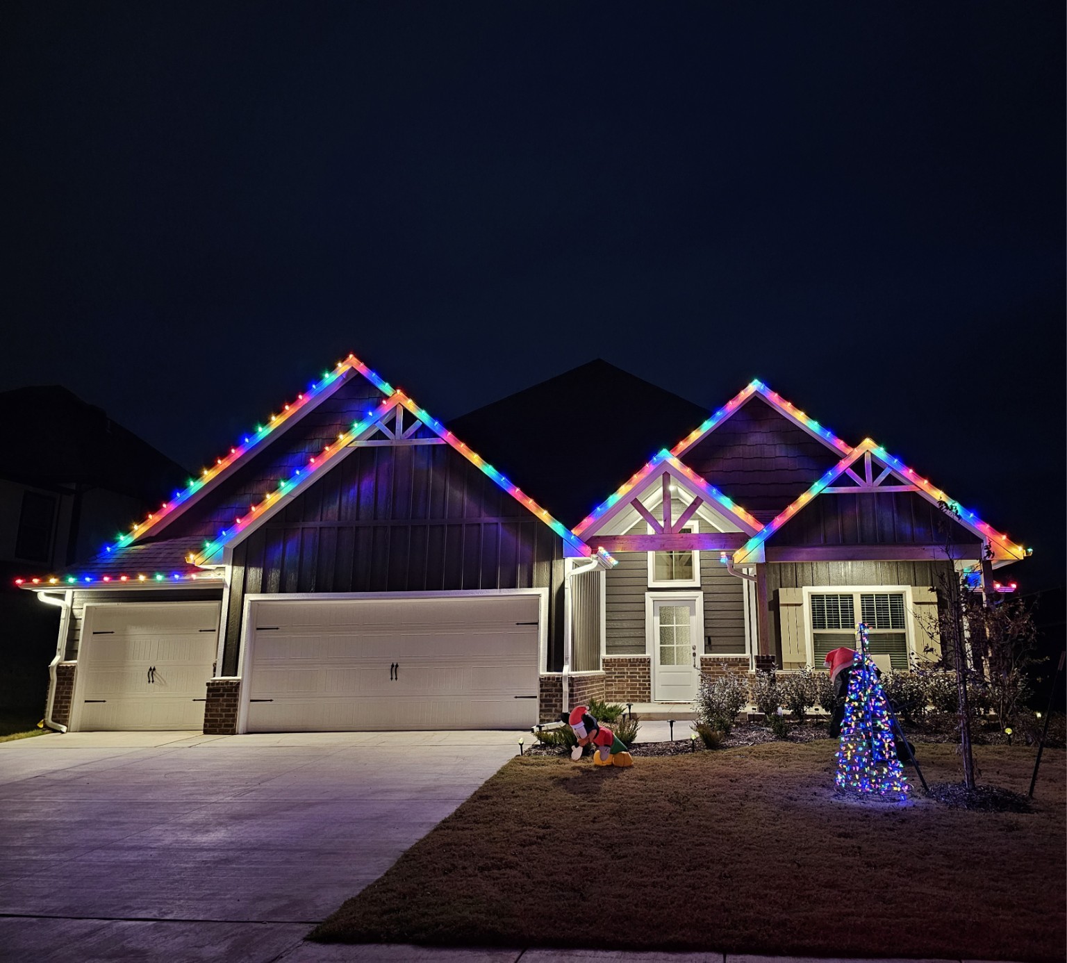 A home with multicolor Christmas lights installed along its roofline